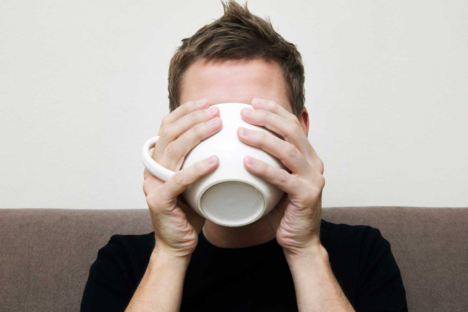 man drinking from mug